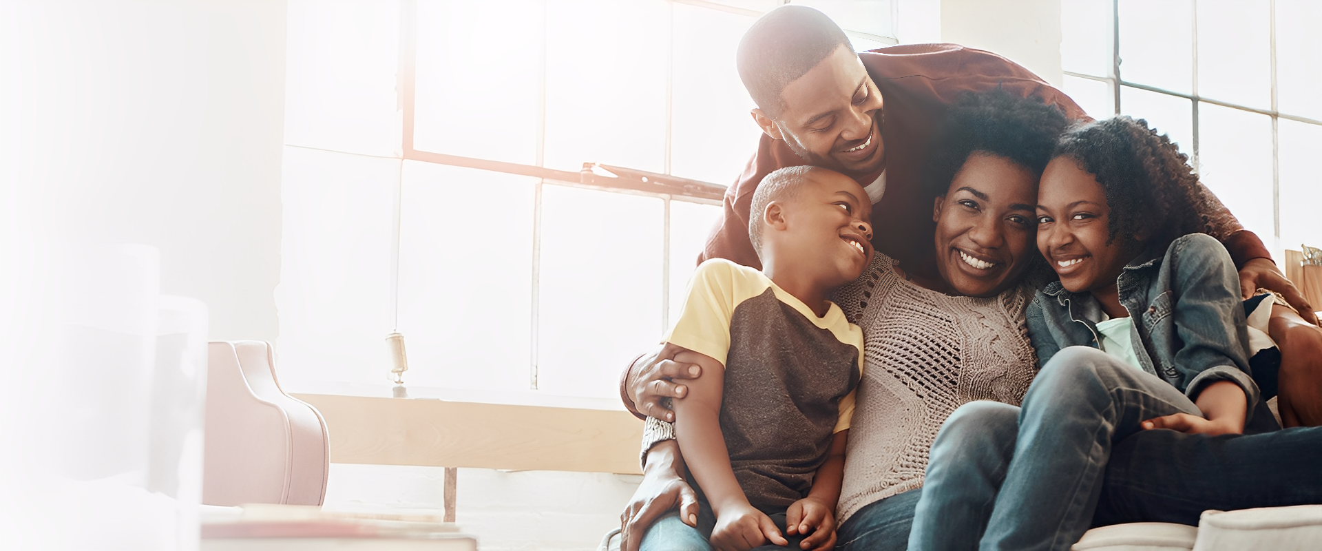 Family laughing together on a cozy couch.