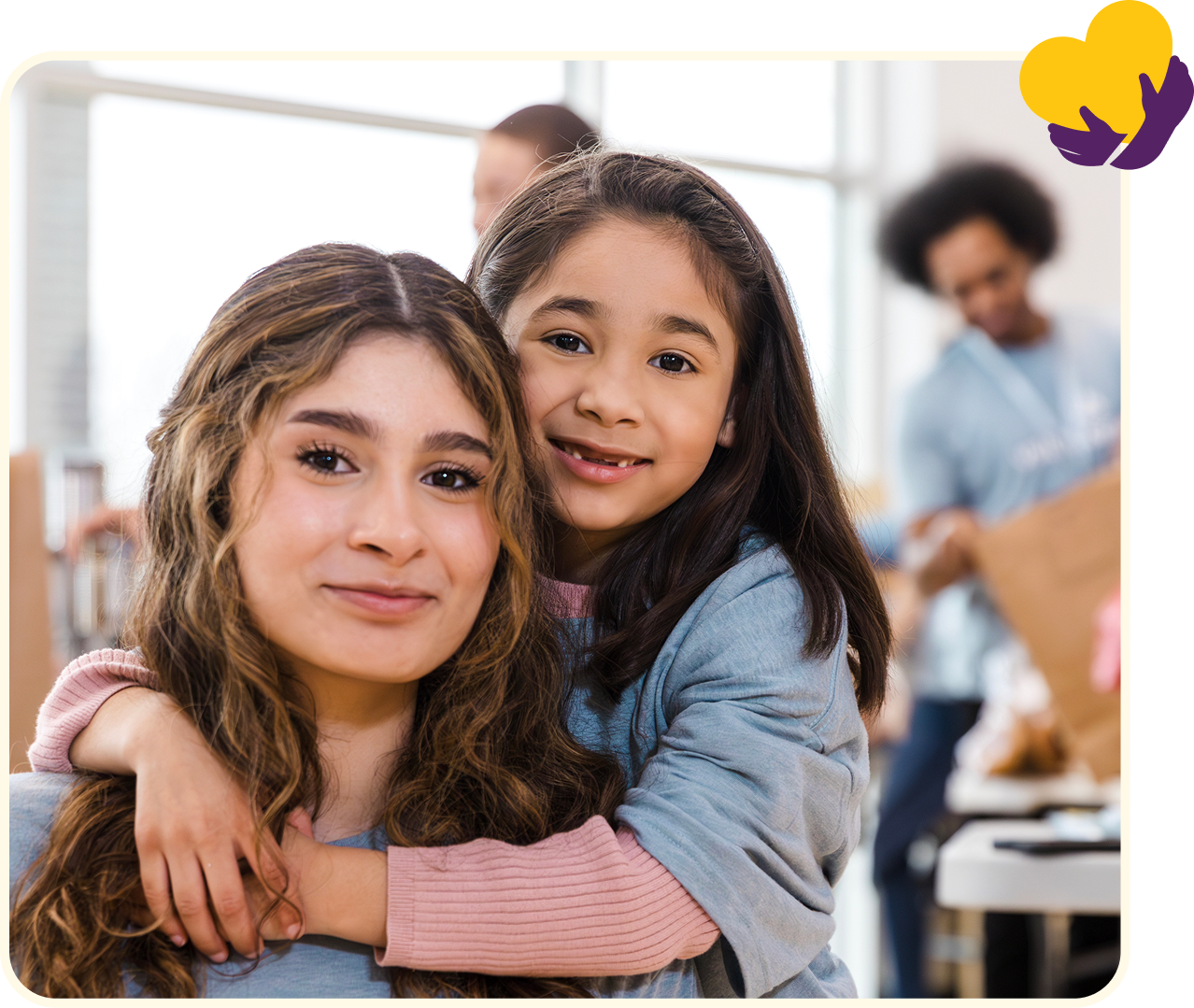 Smiling girl hugging a woman indoors.